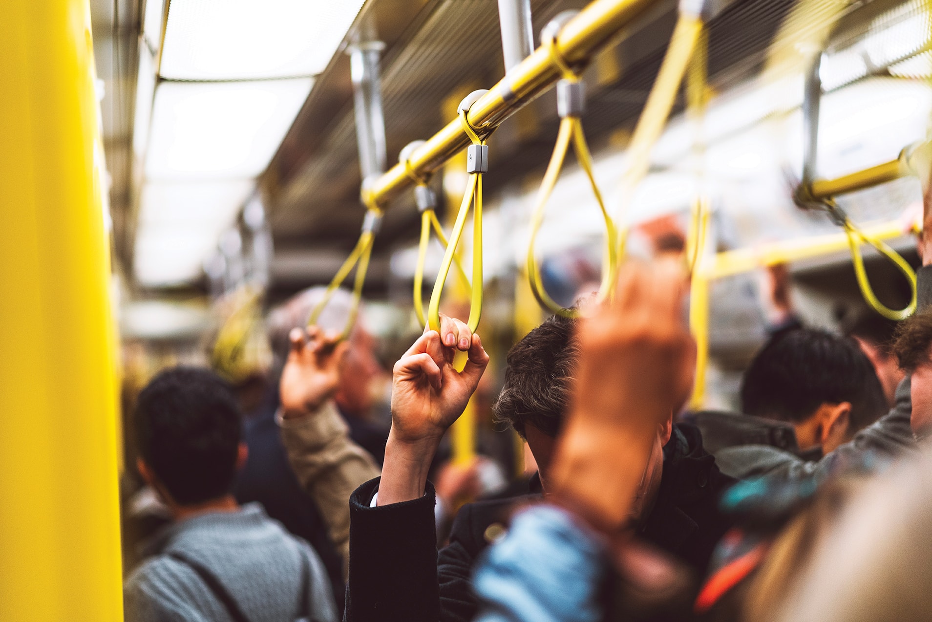 People holding train handles