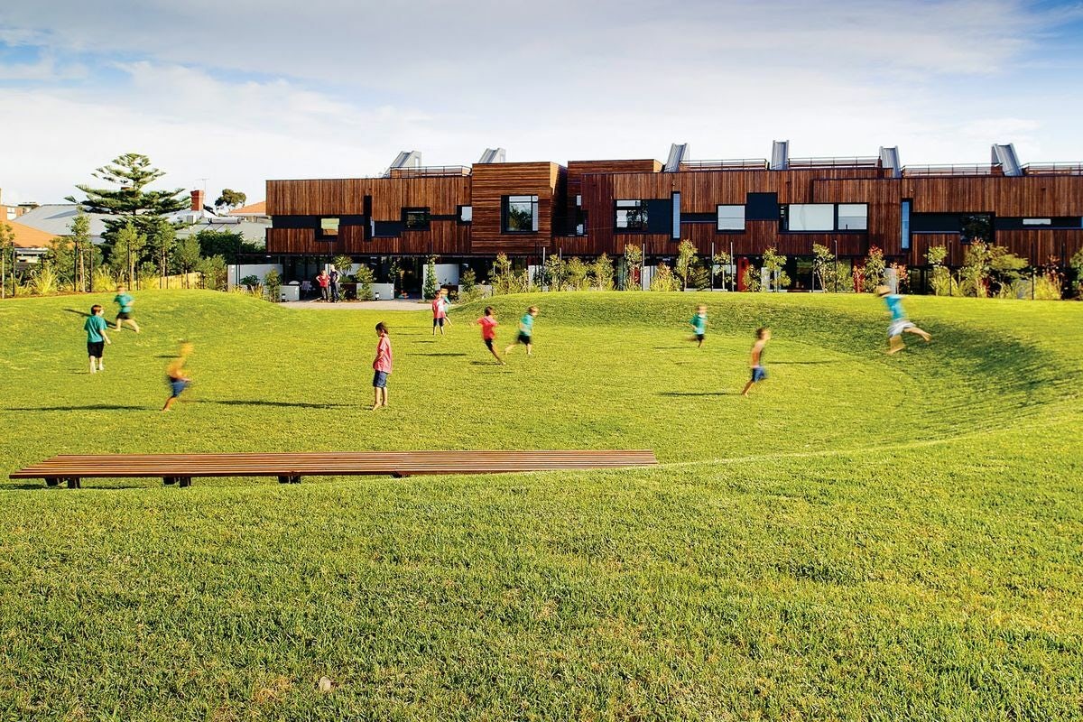 townhouses in background and children playing in park in foreground