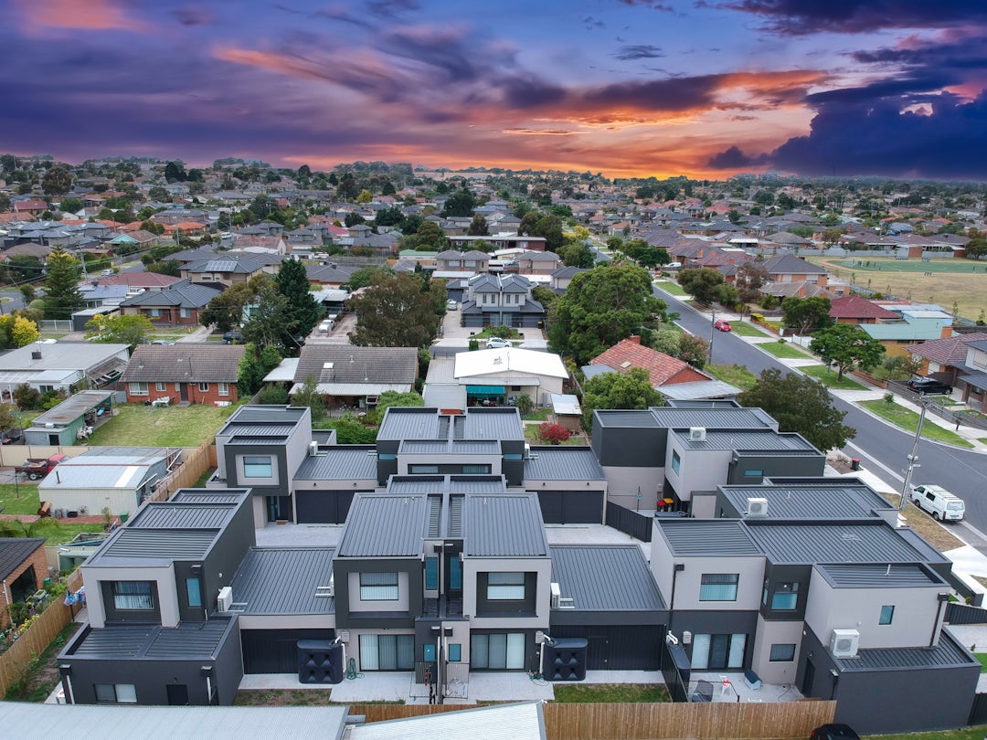 Aerial of new townhouses and suburb at sunset